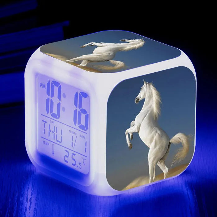 Small colourful square LED alarm clock showing digital time display on plexiglass mirror front