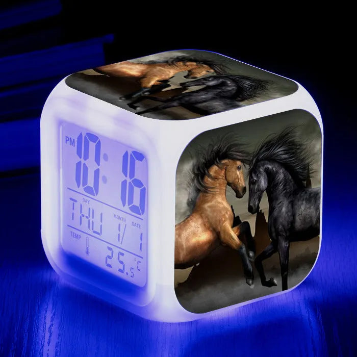 Small colourful square LED alarm clock showing digital time display on plexiglass mirror front