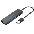 Black four-port USB 3.0 hub with a short connected cable on a white background