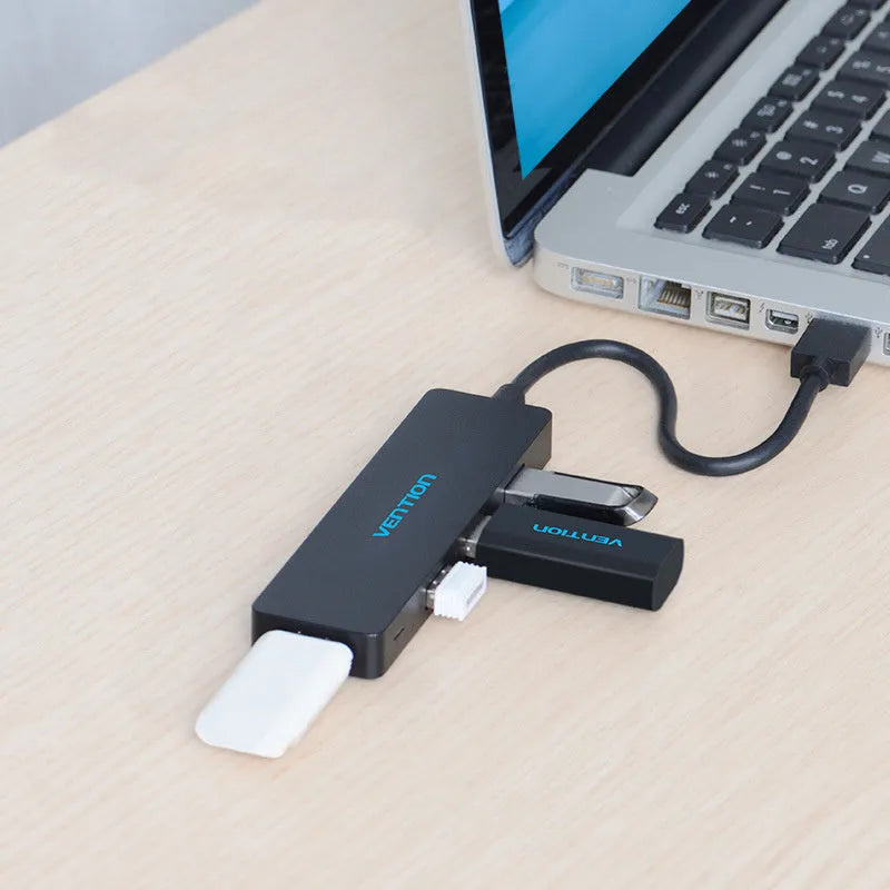 Black four-port USB 3.0 hub with a short connected cable on a white background