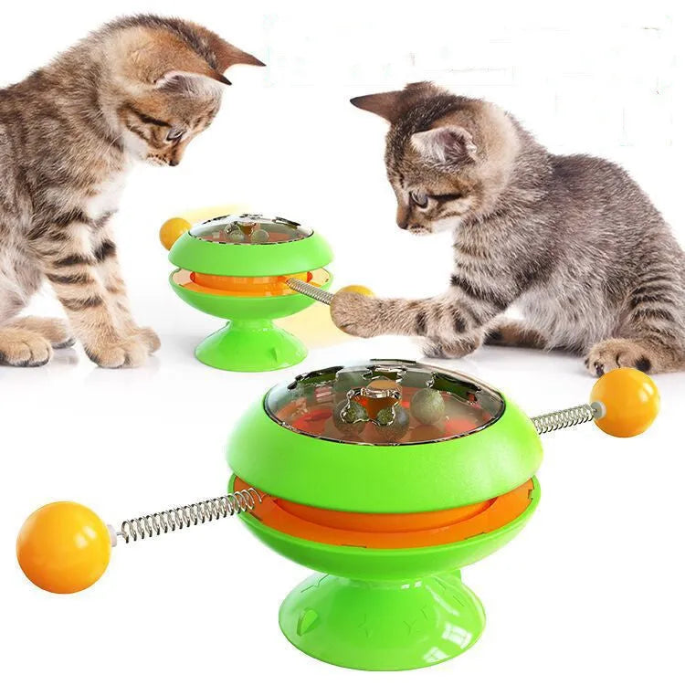 Rotatable interactive cat toy with coloured turntable, transparent top with catnip balls, and a large suction cup base.