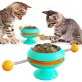 Rotatable interactive cat toy with coloured turntable, transparent top with catnip balls, and a large suction cup base.