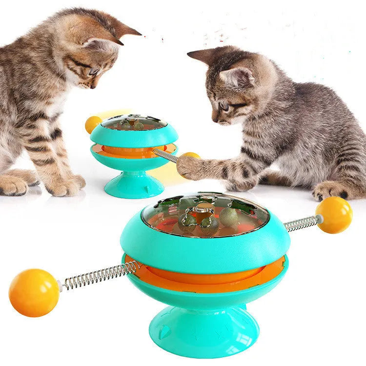 Rotatable interactive cat toy with coloured turntable, transparent top with catnip balls, and a large suction cup base.