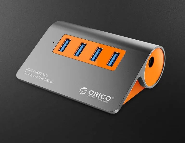 Dark grey aluminium alloy USB 3.1 laptop hub with four ports, orange accents, and detachable cable