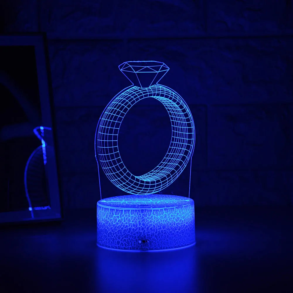 3D stereoscopic LED night light showing an illuminated diamond ring design on a black, white, or cracked white background.