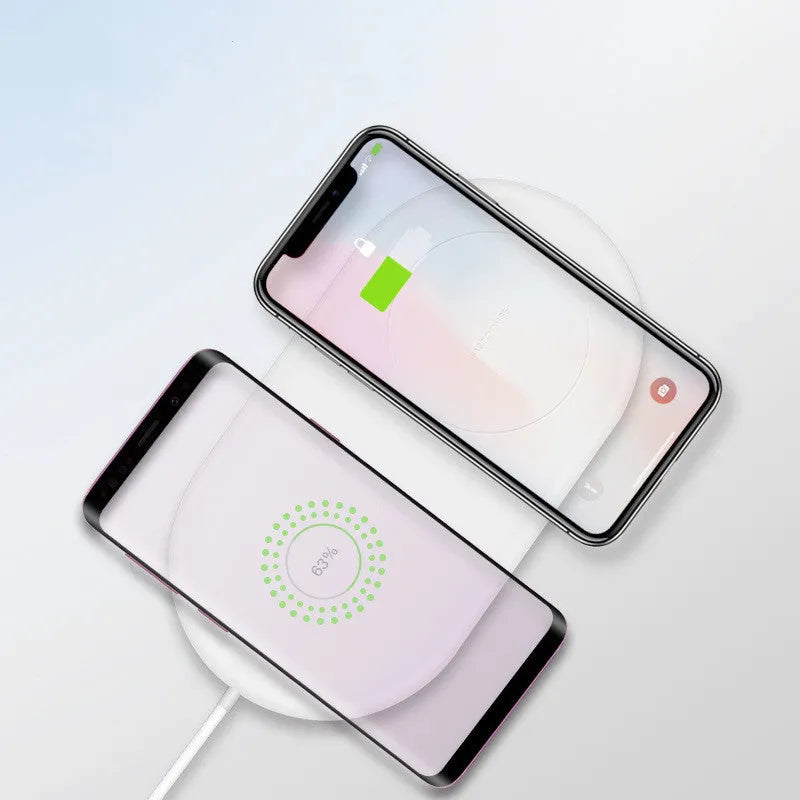 White dual wireless charger charging two mobile phones side-by-side.