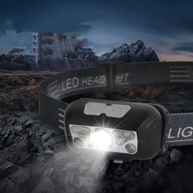 Black and blue outdoor LED headlight with adjustable strap, showing white and red LEDs and a micro-USB port.