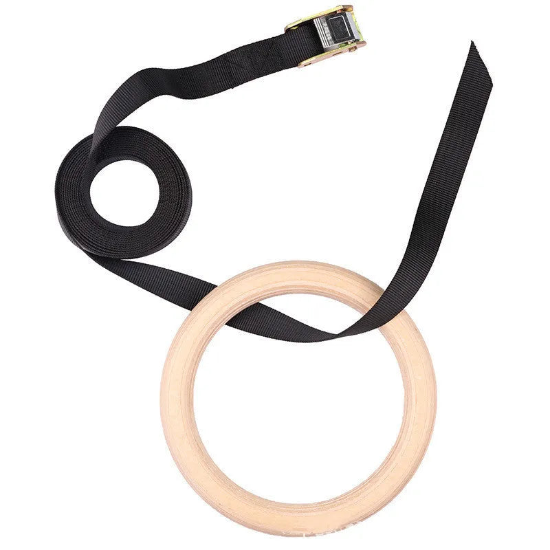 Birch wood gymnastics rings with nylon straps on a pull-up bar in a home gym setting