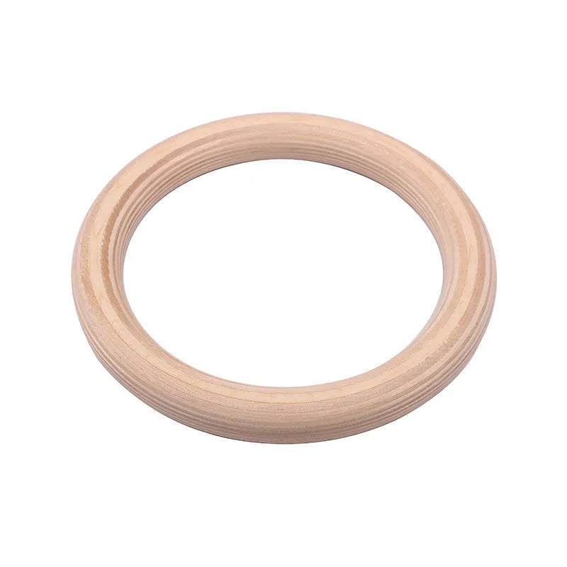 Birch wood gymnastics rings with nylon straps on a pull-up bar in a home gym setting