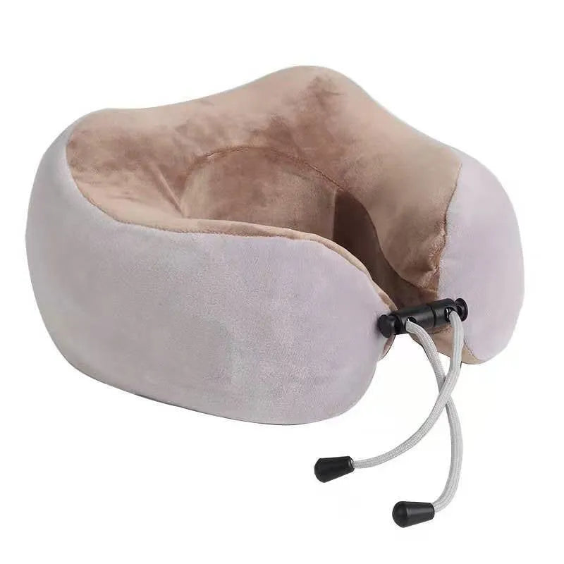 Brown U-shaped electric neck massage pillow with control buttons, shown on a table.