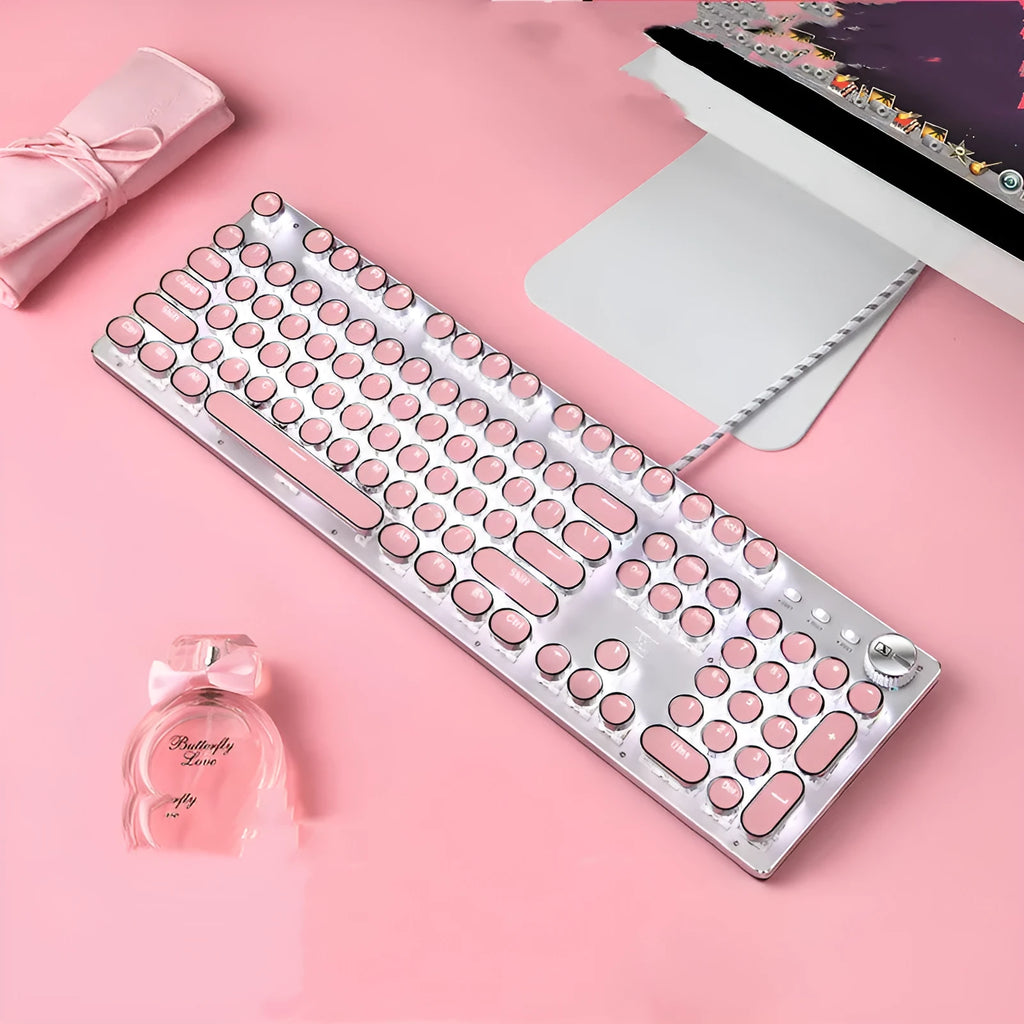 Pink and silver mechanical keyboard with green switches and white backlighting, alongside a wired mouse.