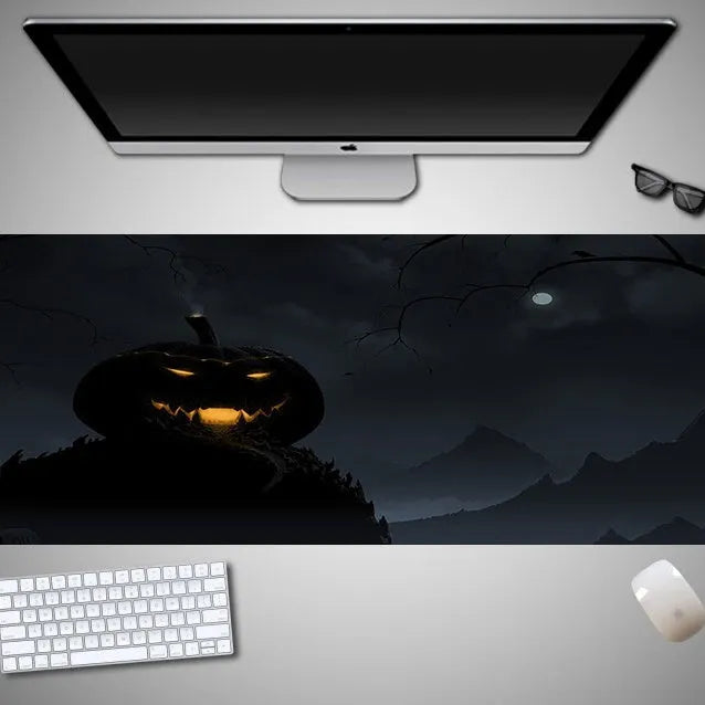 Oversized black Halloween-themed mouse pad with spooky artwork on a desk next to a gaming mouse.