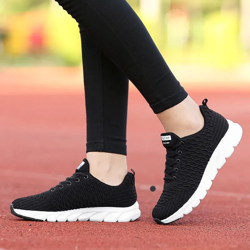 Women's running shoes with fly weave upper in Black, Pink, or White colours showing wear-resistant outsole