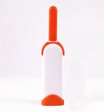 Blue reusable pet hair removal brush with a self-cleaning base, placed on a grey sofa.