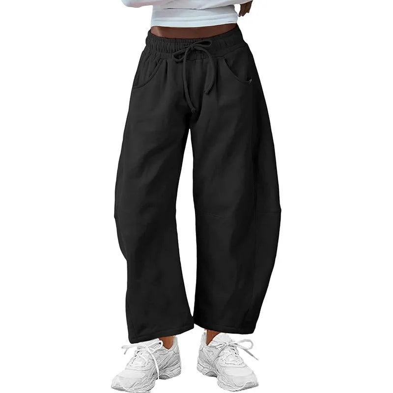 Loose grey cropped sweatpants with elastic drawstring waist and pockets on a mannequin