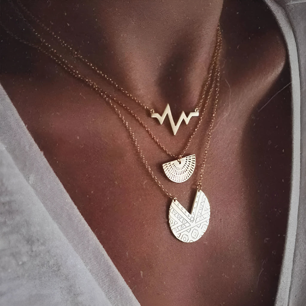 Gold multi-layer round alloy necklace with electroplated finish on white background