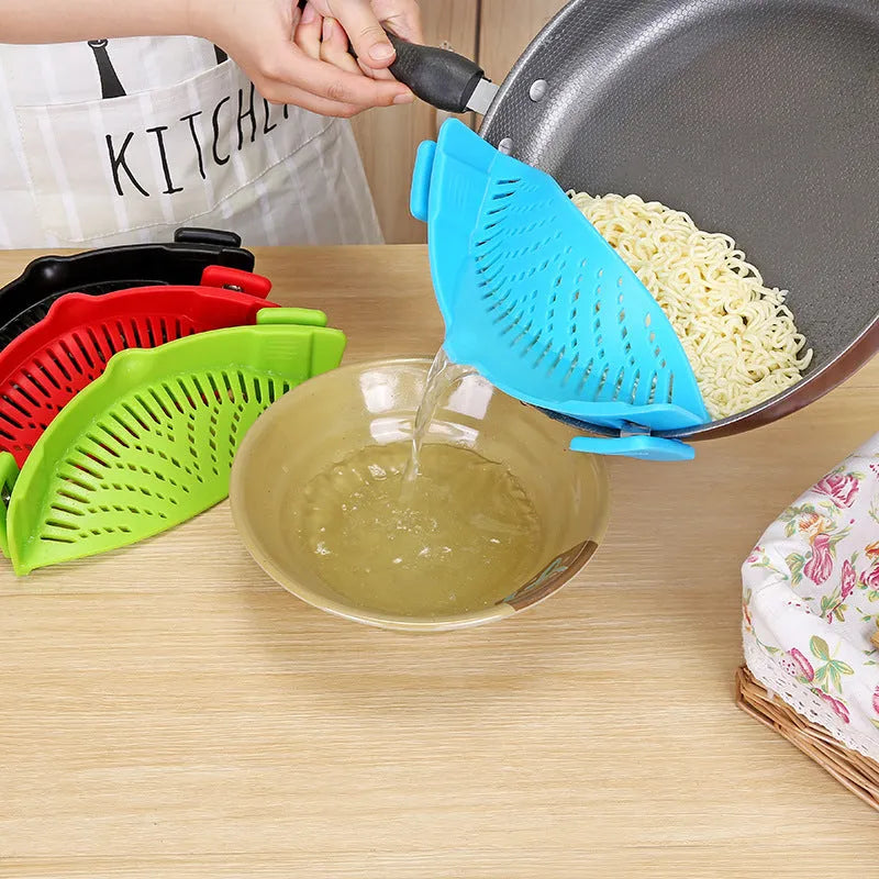 Silicone clip-on funnel strainer attached to a pot rim, showing hollow design and stainless steel buckle.