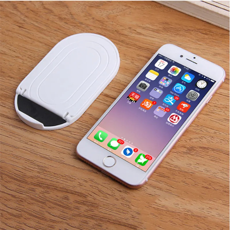 Plastic lazy bracket mobile phone stand shown in one of six available colours: black, blue, grey, pink, white, or yellow.