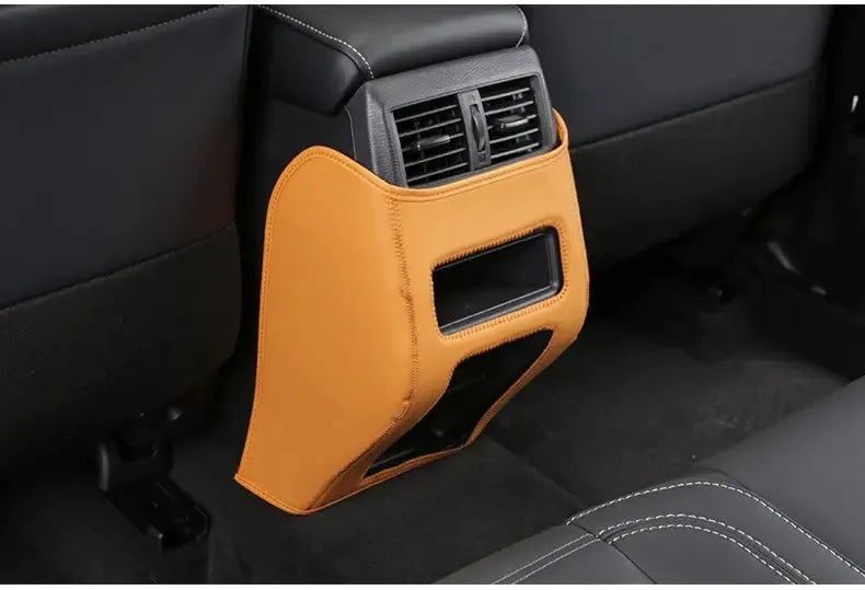 Set of three leather anti-kick pads for Mitsubishi Outlander seats and console in black, grey, and brown.