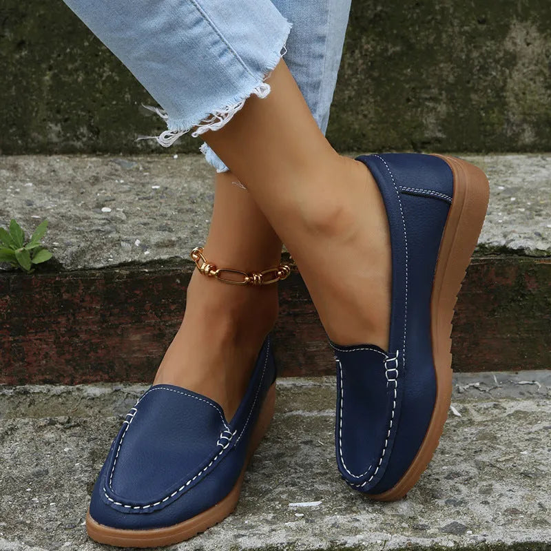 Women's black PU leather flat shoes with round toe and visible car suture stitching detail.