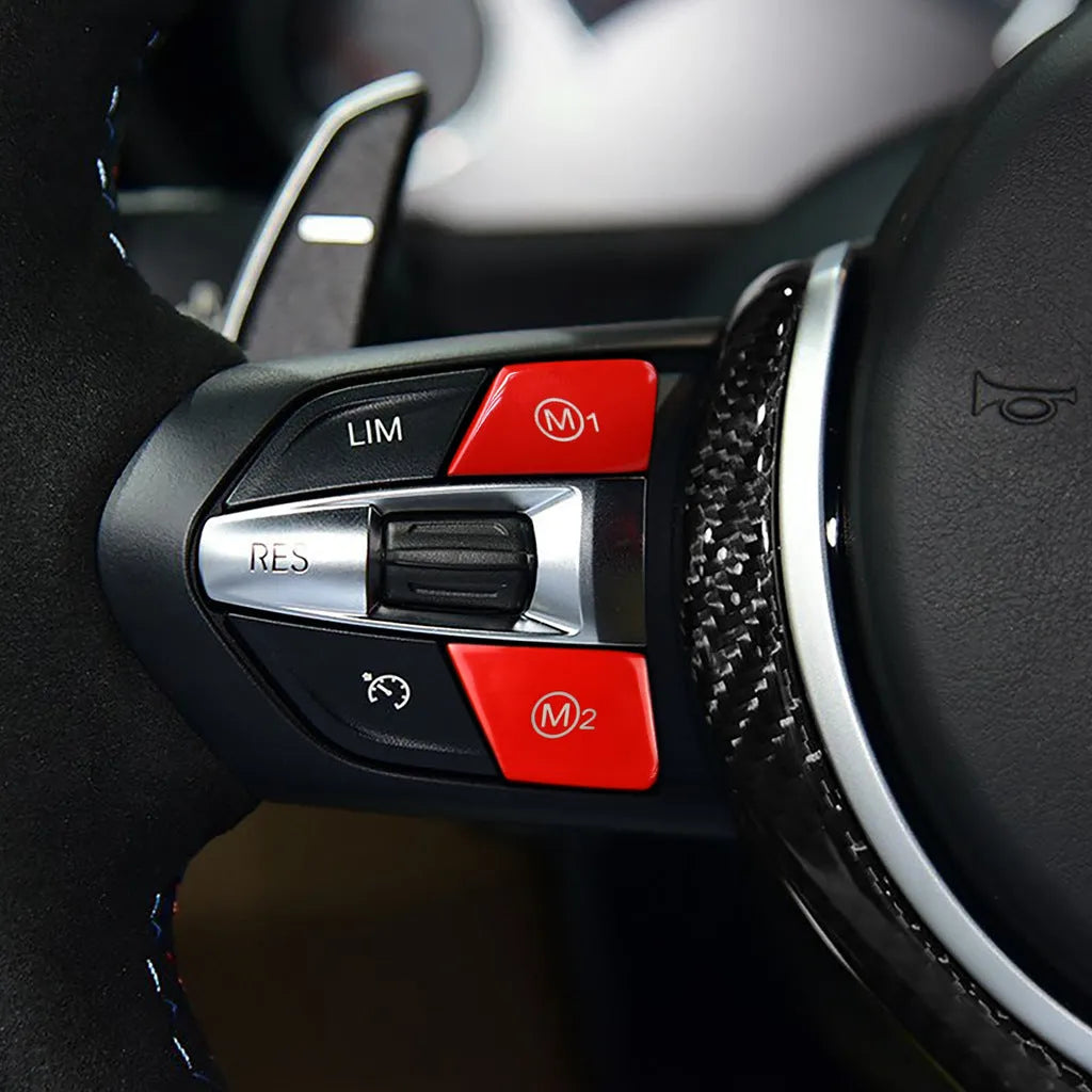 Red and blue BMW M1 M2 steering wheel button accessories with installation keys on a black background