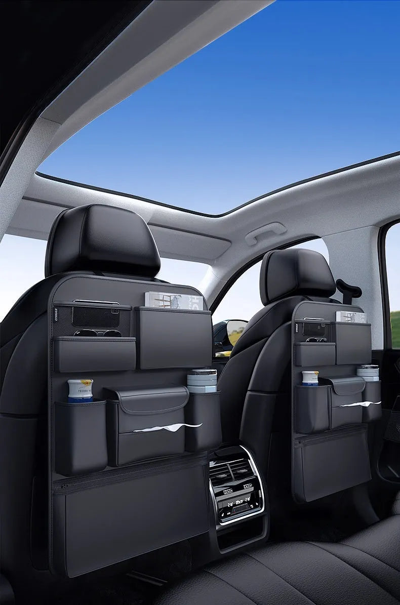 Black leather car seat back hanging storage bag with carrying handle shown in vehicle