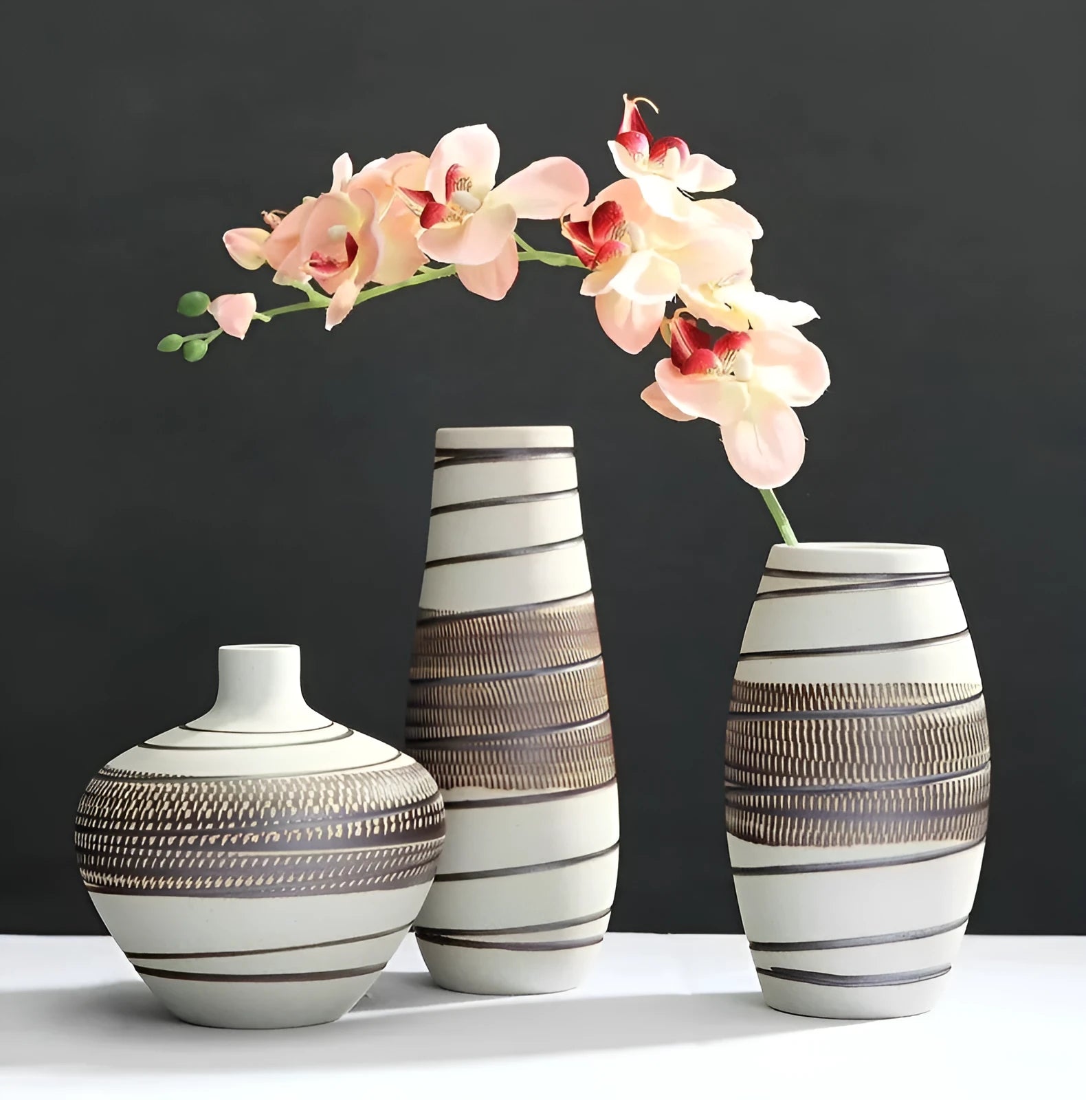 Three-piece ceramic vase set in low, medium, and tall sizes with vintage finish on a tabletop