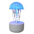 White jellyfish-shaped desktop humidifier and essential oil diffuser with colourful night light on.