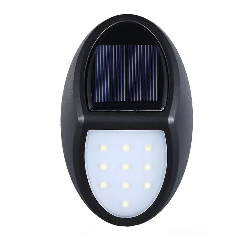 Black rectangular LED solar-powered outdoor wall light mounted on a fence.