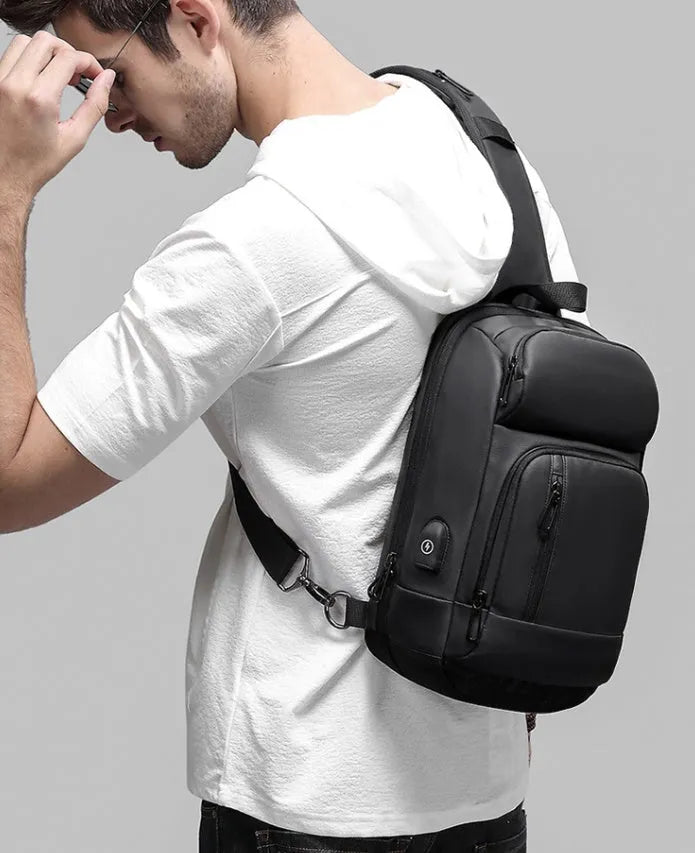 Black PVC medium shoulder bag with multiple internal compartments and adjustable strap