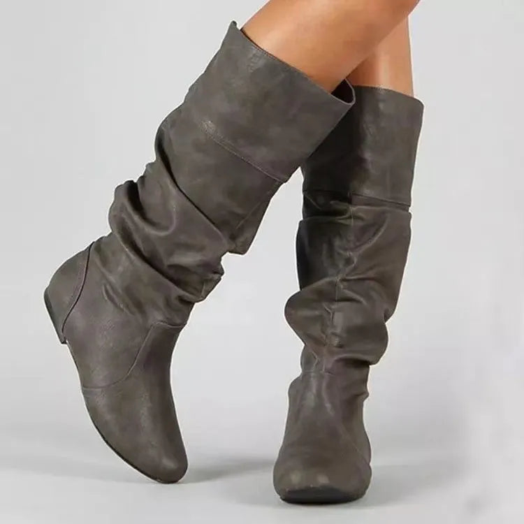 Women's flat ankle boots in black with a round toe and slip-on design on a rubber sole.