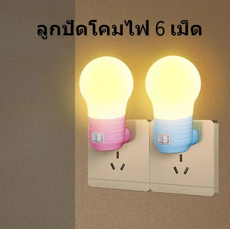 Plug-in bedside baby night light in white shell with modern round design on a table.