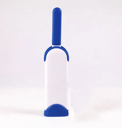 Blue reusable pet hair removal brush with a self-cleaning base, placed on a grey sofa.