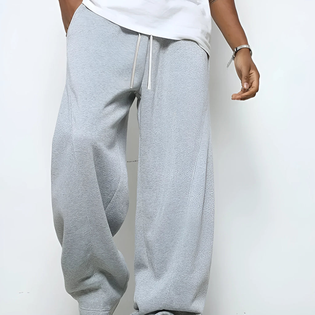 Men's straight leg casual trousers in black with a drawstring waist, laid flat.