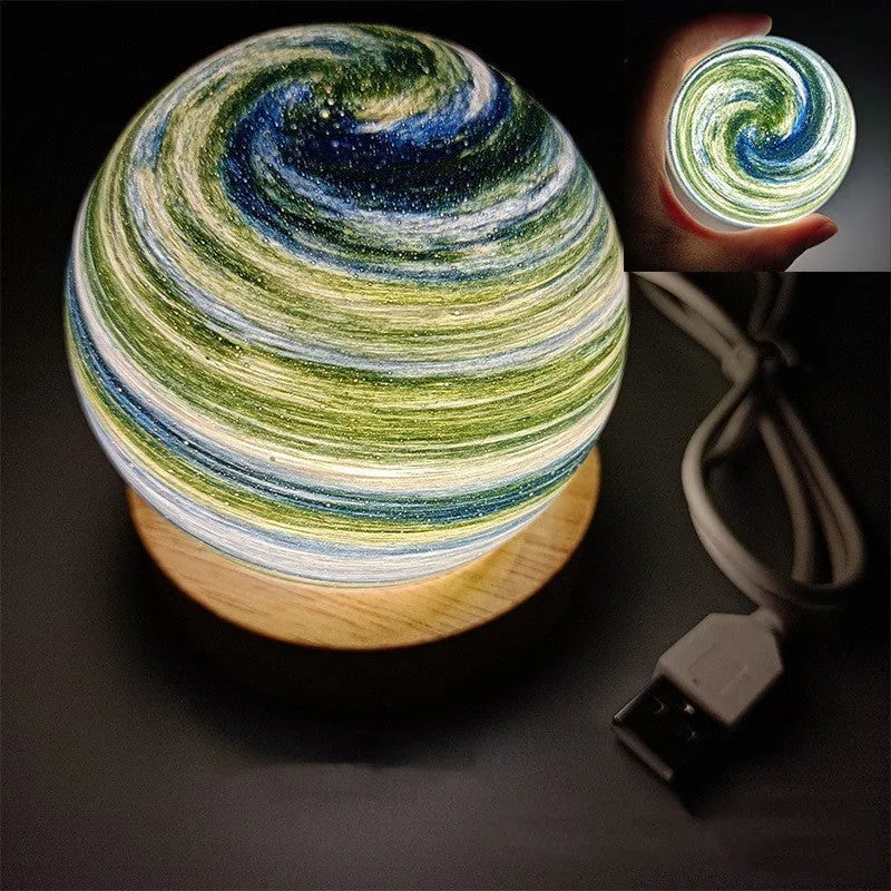Planet night light with spherical design on base, USB cable connected, showing adjustable three-colour lighting