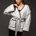 Loose fit camel coloured knitted cardigan sweater with long sleeves laid flat.