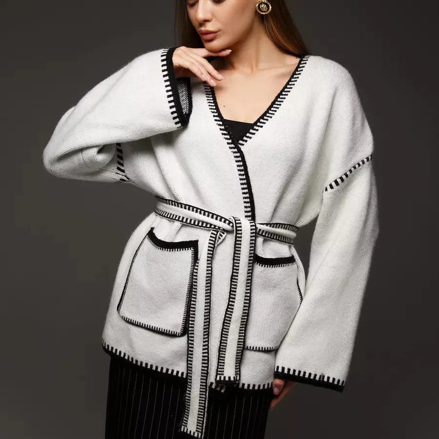 Loose fit camel coloured knitted cardigan sweater with long sleeves laid flat.