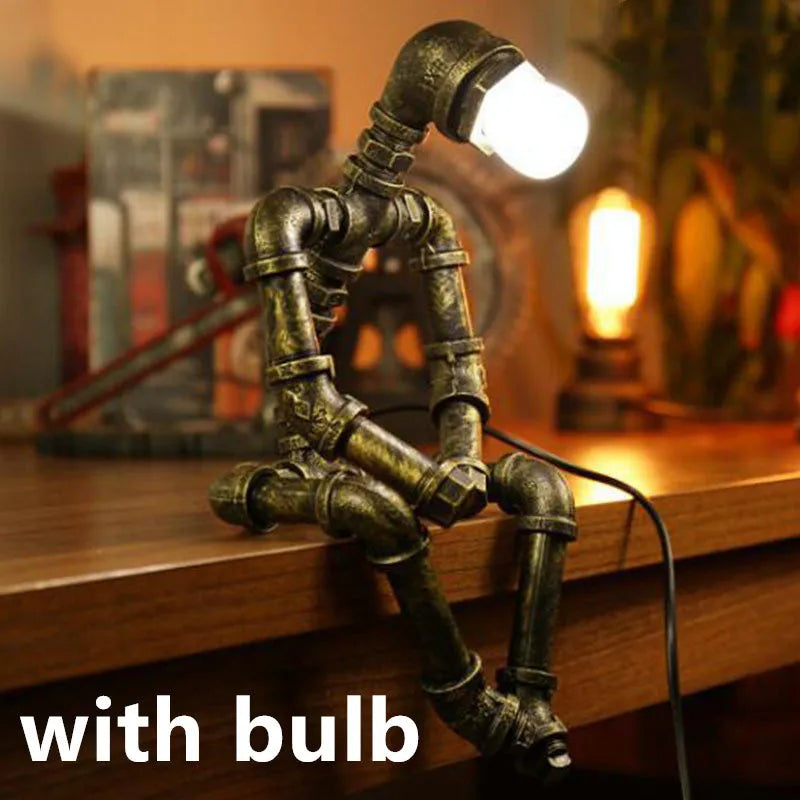 Green bronze vintage industrial iron pipe desk lamp on a wooden table.