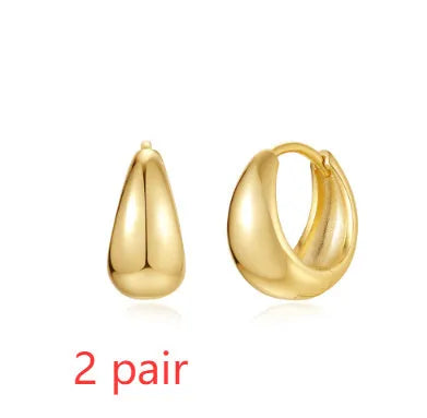 Geometric brass earclip earrings with round elements in golden and gold finishes