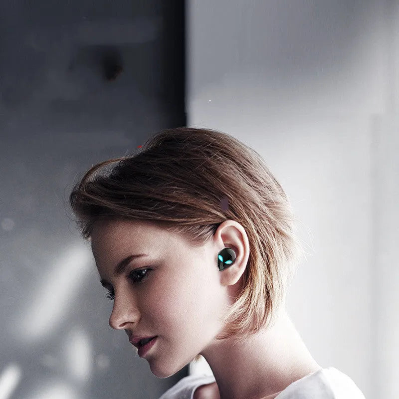 Creative Outer T8 Starman alien design wireless earbuds with LED lights next to charging case.