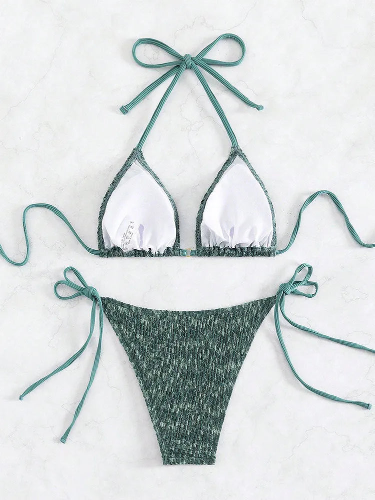 Women's green halter strap backless swimsuit top with matching shorts on hanger