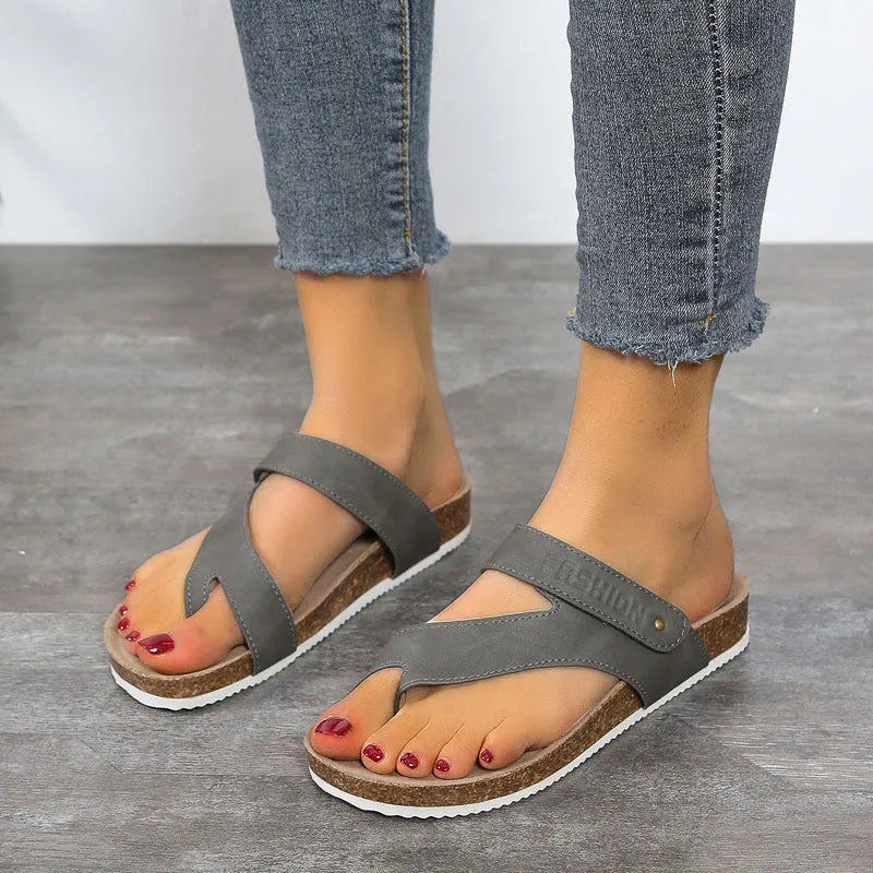 A pair of thick-soled flat toe ring flip-flops in a solid colour on a white background.