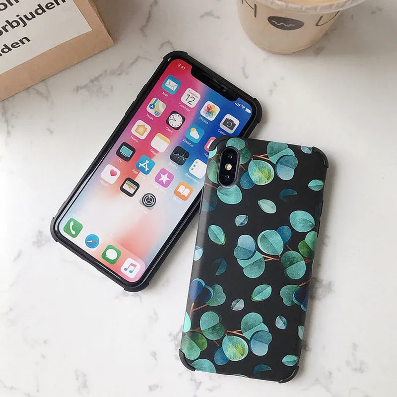 Black silicone iPhone case with a leaf pattern design on a table.