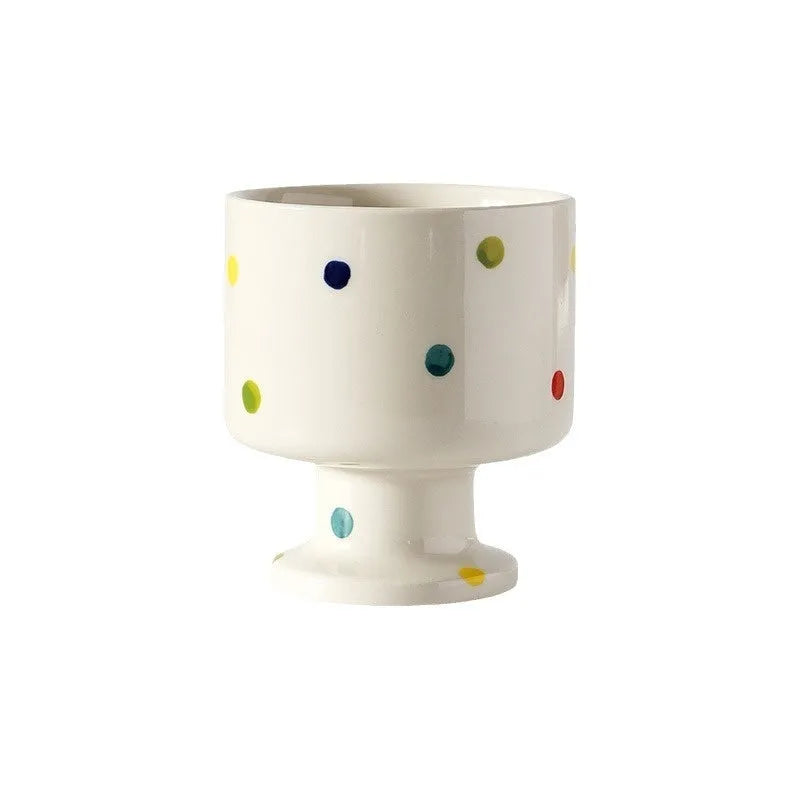 Hand-pinched irregular shaped ceramic mug in a solid colour on a table.