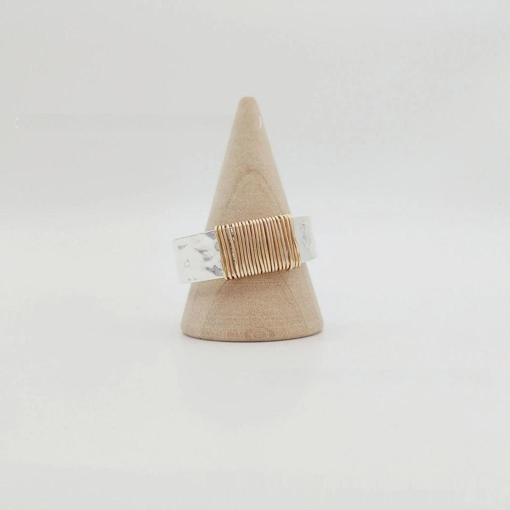 Geometric copper bracelet with irregular coil pattern forming silver-gold wide-faced ring design