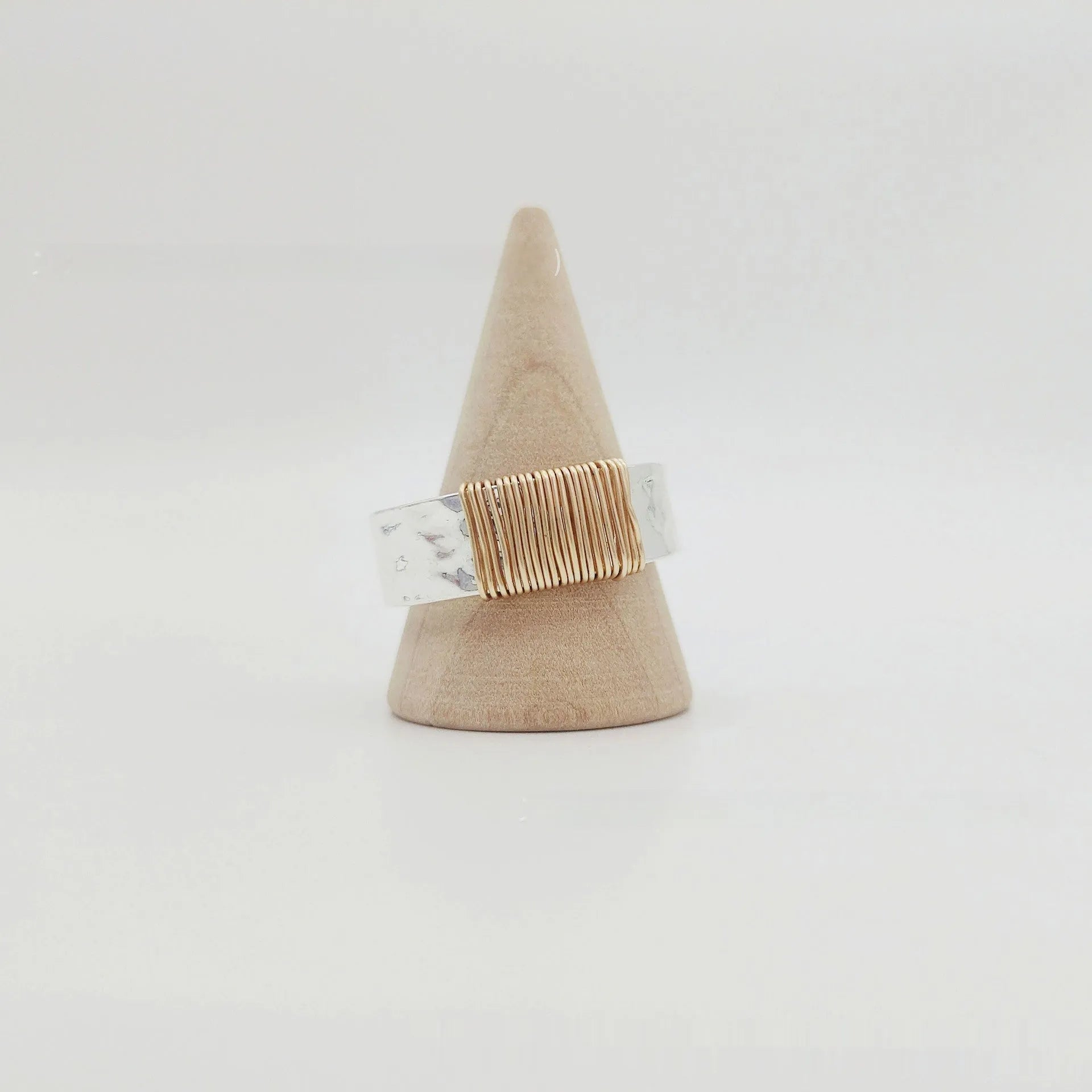 Geometric copper bracelet with irregular coil pattern forming silver-gold wide-faced ring design