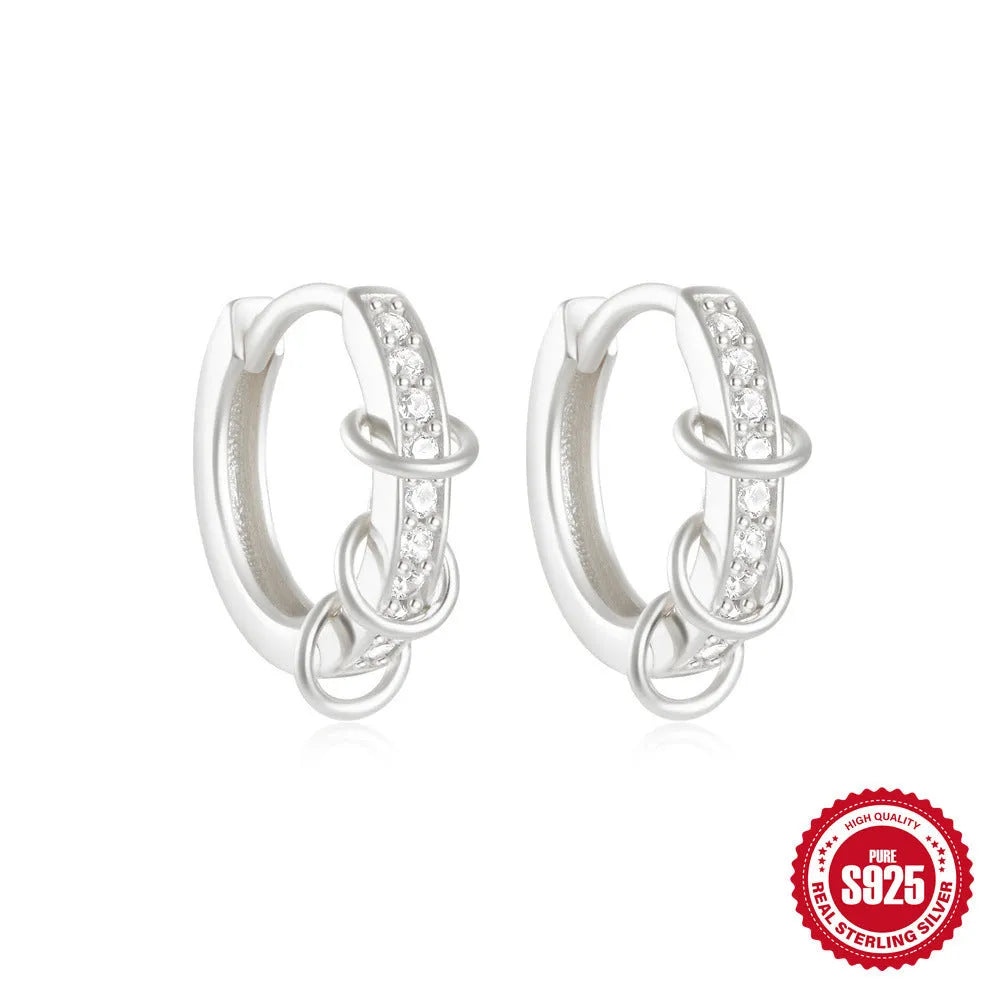 A pair of small, round, geometric stud earrings made of sterling silver with an electroplated finish.