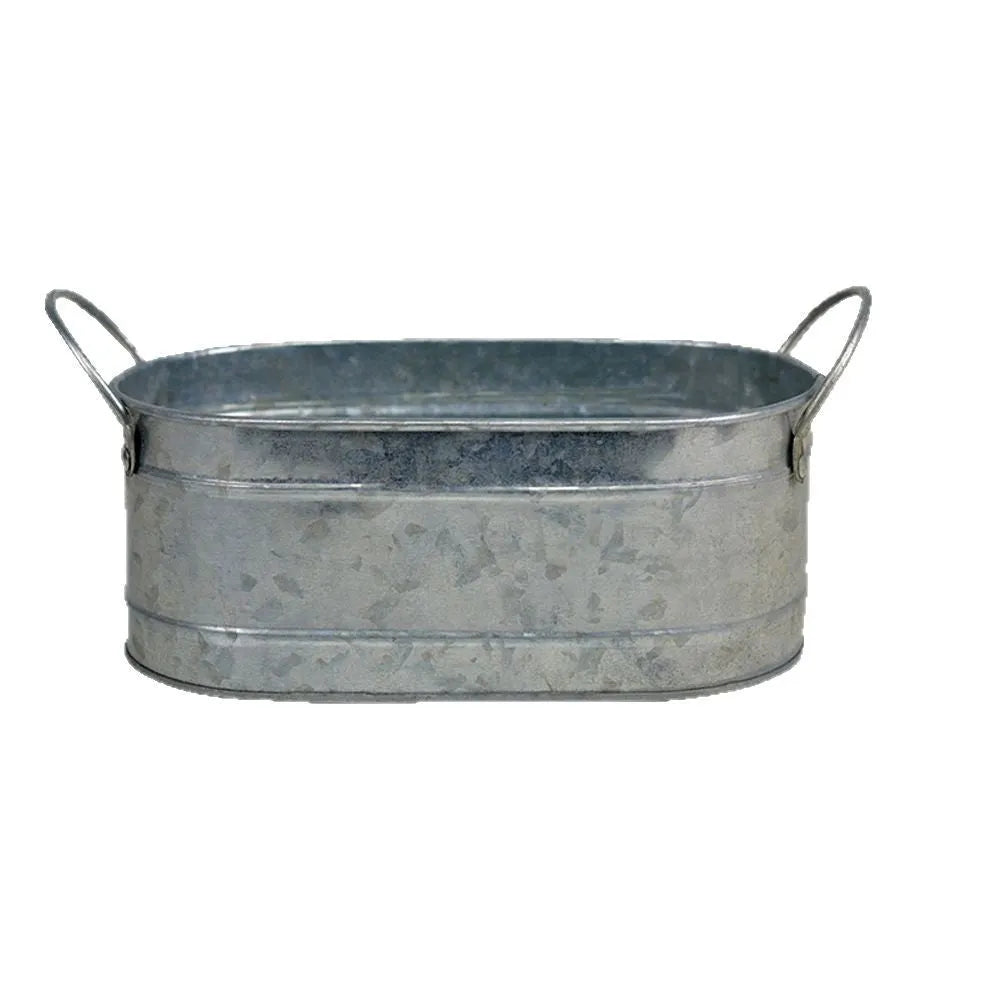 Galvanised iron cylindrical succulent flower pot with a drainage hole on a desk.