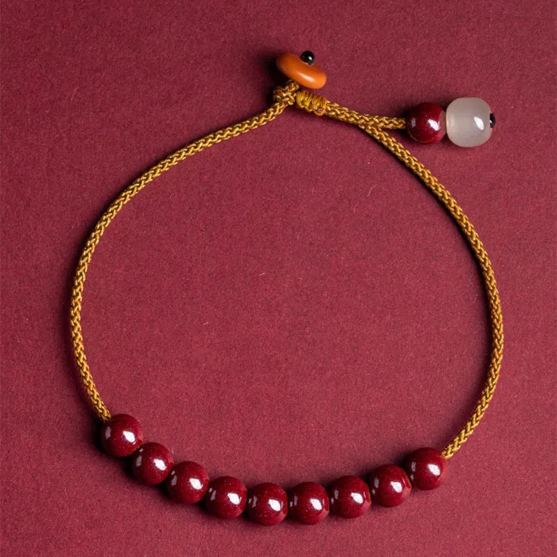 Hand-woven bracelet made from raw cinnabar ore and Hetian jade in a simple geometric shape.