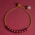 Hand-woven bracelet made from raw cinnabar ore and Hetian jade in a simple geometric shape.